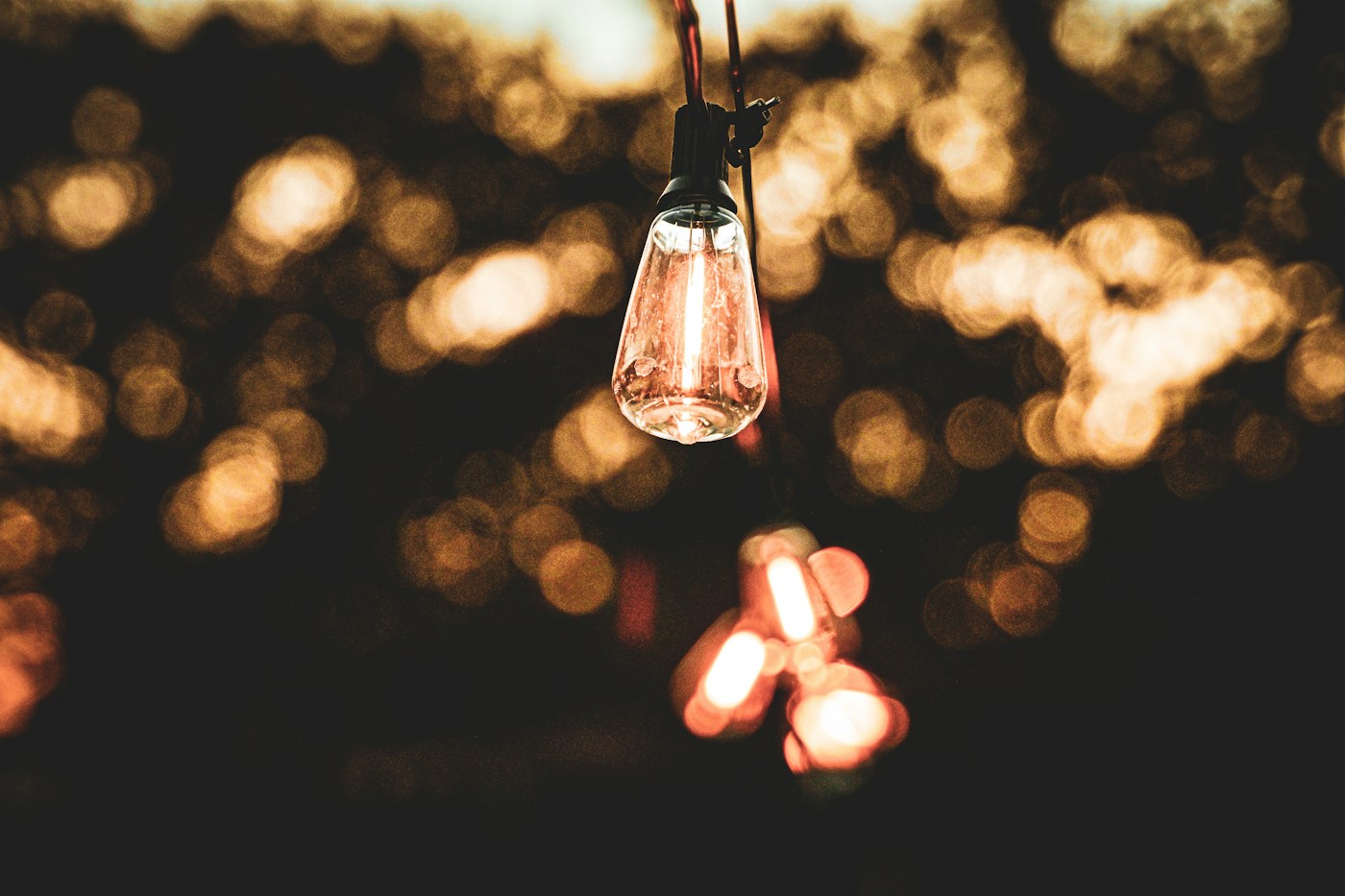 A glowing light bulb surrounded by soft amber light